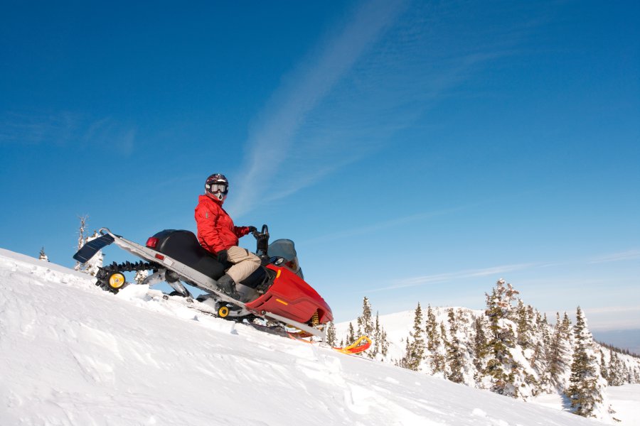 man in red anorak on a snowmobile